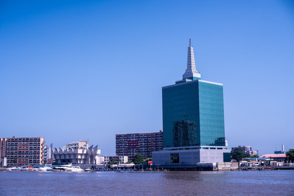 a tall building featuring a distinctive green roof, showcasing modern architecture and sustainable design elements.